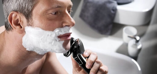 man uses Philips Norelco SensoTouch 3D/1250x shaver in bathroom
