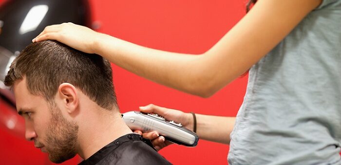 a woman cutting a man's hair