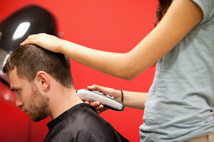 cutting woman's hair with clippers