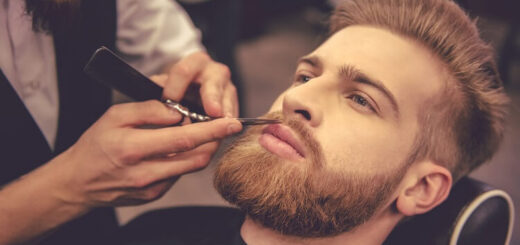a young attractive man having his beard trimmed