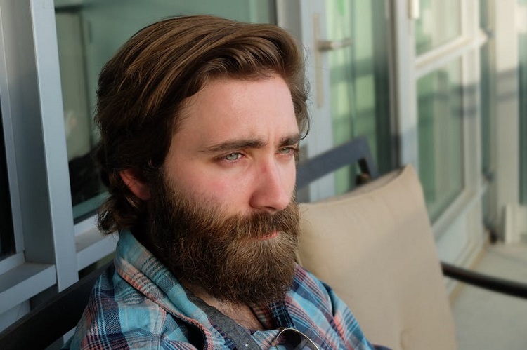 a man's face with thick hair and beard