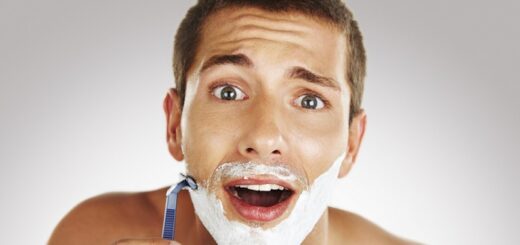 a young man looking surprised while shaving