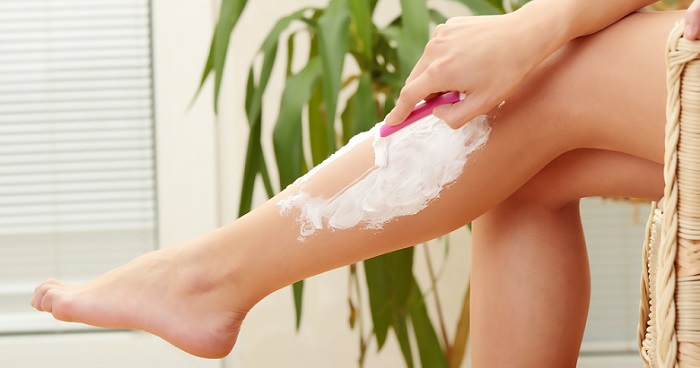 a woman shaving her legs