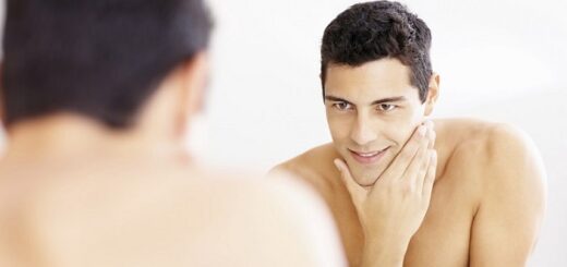 the reflection of a young man looking in the mirror with a freshly-shaved face