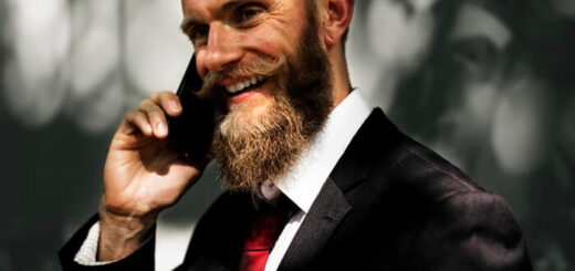 elegant business man smiling with long beard talking at the phone