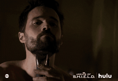 man is confidently using a shaver to shave off his beard