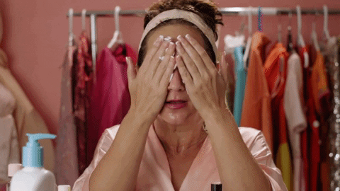 woman putting a facial cream all over her face