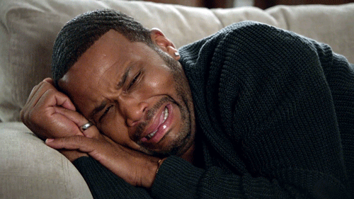 man is weeping while lying down on the sofa