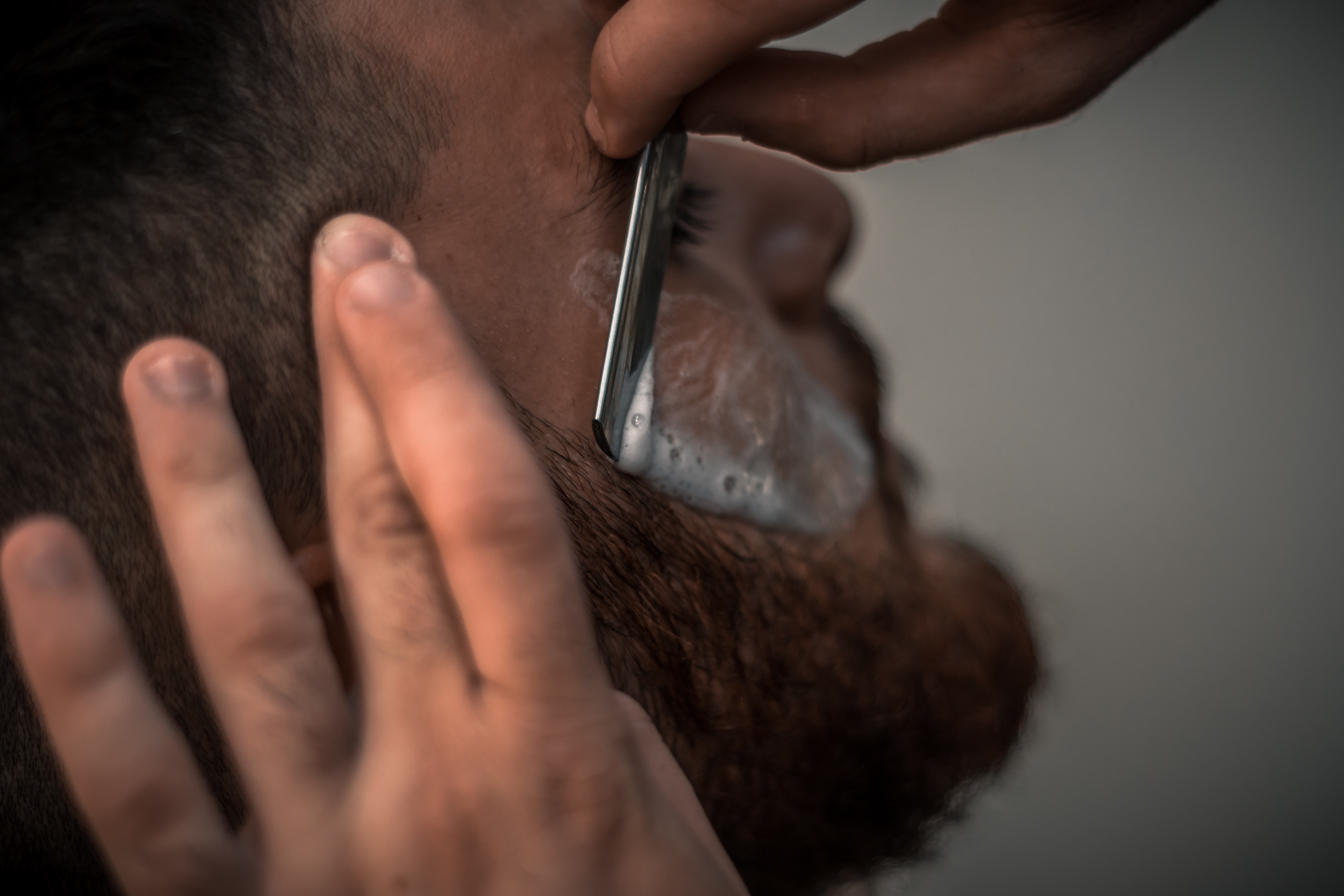 man having his beard shaved